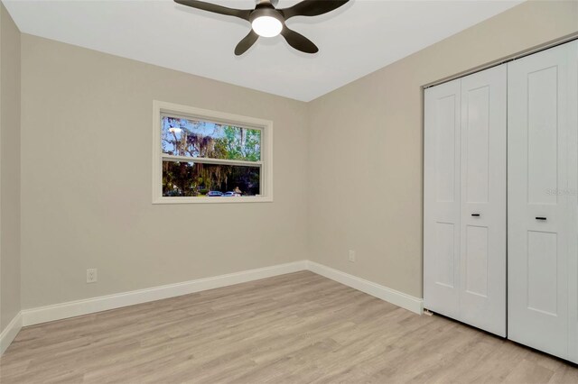 unfurnished bedroom with ceiling fan, a closet, and light hardwood / wood-style flooring