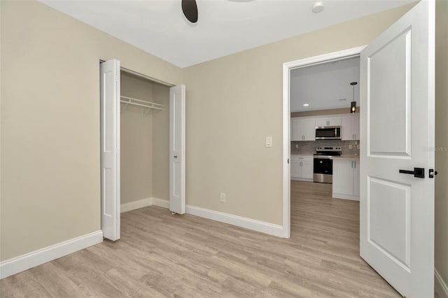 unfurnished bedroom featuring ceiling fan, a closet, and light hardwood / wood-style floors