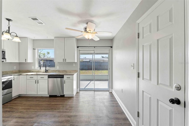 kitchen with decorative light fixtures, white cabinetry, stainless steel appliances, and a wealth of natural light