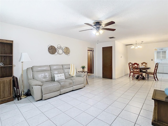 tiled living room with ceiling fan with notable chandelier