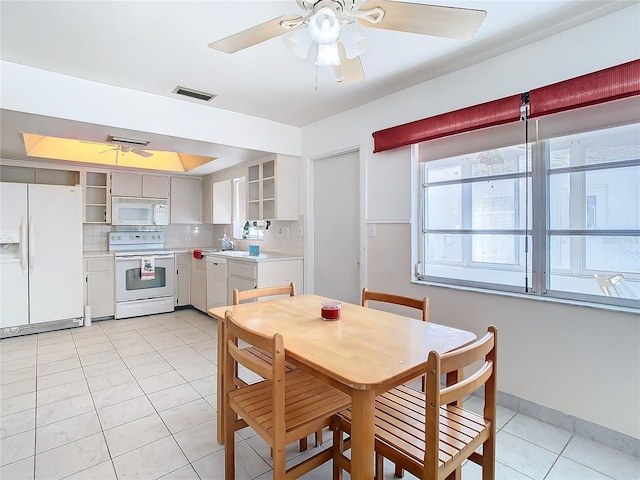 tiled dining area featuring ceiling fan and sink