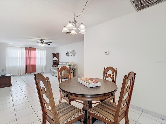 tiled dining area featuring ceiling fan with notable chandelier