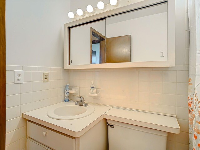 bathroom with tasteful backsplash, vanity, and tile walls