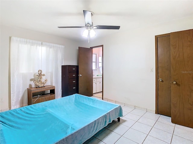 tiled bedroom featuring ceiling fan and ensuite bath