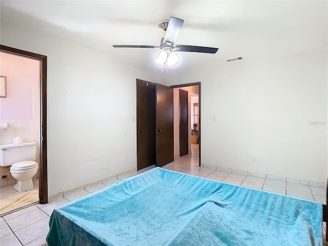 tiled bedroom featuring ceiling fan and ensuite bathroom