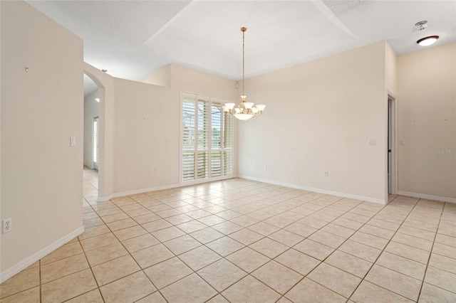 empty room with a chandelier and light tile patterned flooring