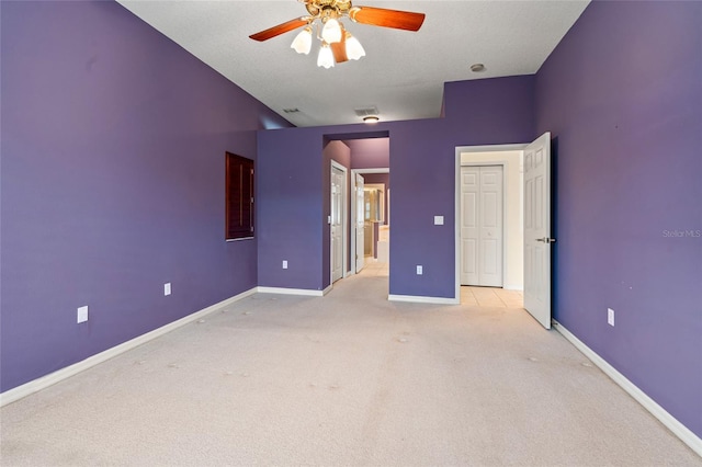 unfurnished bedroom with light carpet, a textured ceiling, and ceiling fan