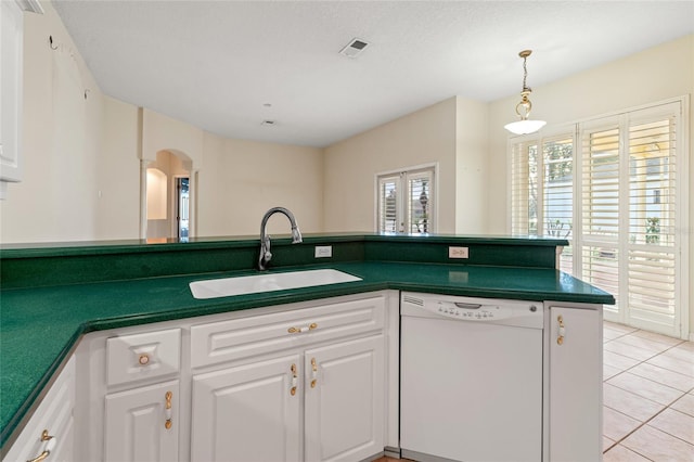 kitchen featuring dishwasher, sink, light tile patterned floors, a textured ceiling, and white cabinets