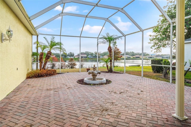 view of patio with a water view and a lanai