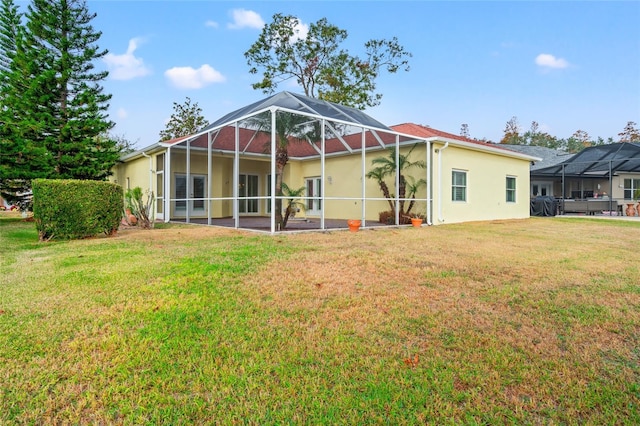 rear view of house featuring a lanai and a yard