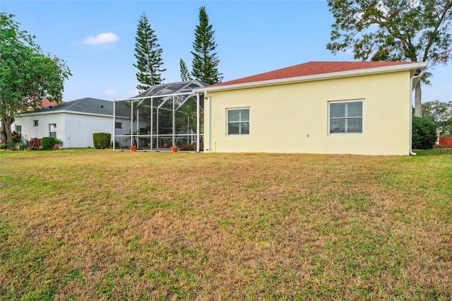 back of house with a lanai and a yard