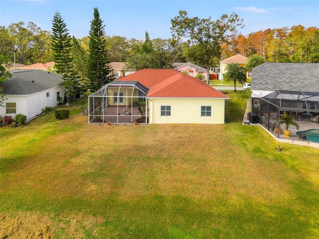 back of house with a lawn and a lanai