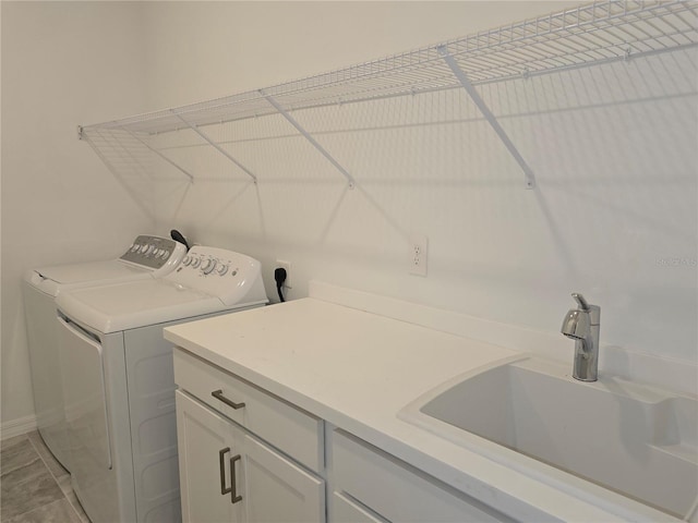 laundry area featuring cabinets, independent washer and dryer, and sink