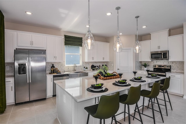 kitchen featuring white cabinets, a kitchen island, sink, and stainless steel appliances