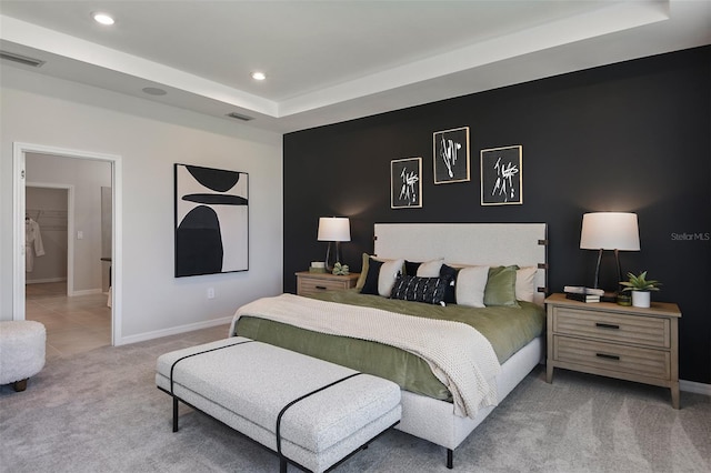 bedroom featuring a tray ceiling and light carpet