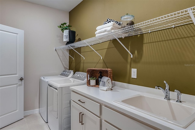 clothes washing area featuring washer and dryer, light tile patterned flooring, cabinets, and sink