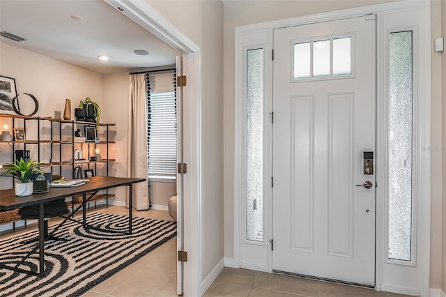 foyer featuring light tile patterned floors and a healthy amount of sunlight