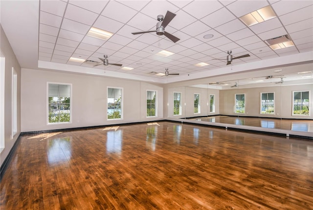 workout room featuring hardwood / wood-style floors, a healthy amount of sunlight, and a drop ceiling