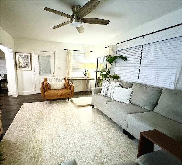 living room featuring ceiling fan and dark wood-type flooring