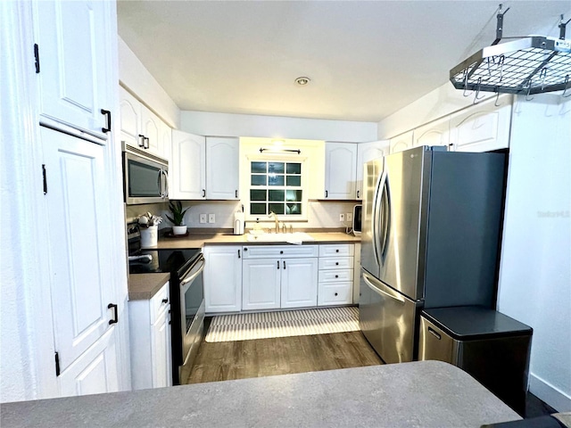 kitchen with dark hardwood / wood-style floors, sink, white cabinetry, and stainless steel appliances