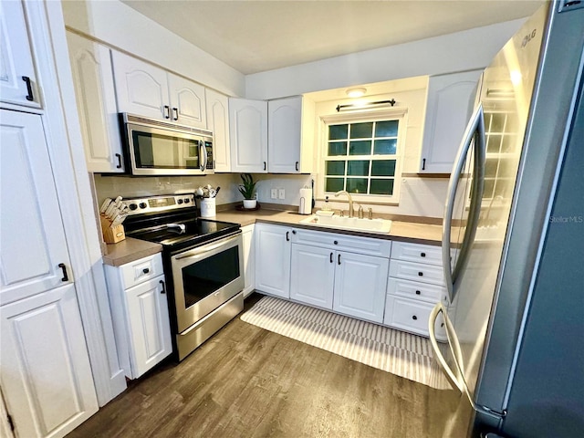 kitchen featuring dark wood-type flooring, sink, white cabinets, and stainless steel appliances