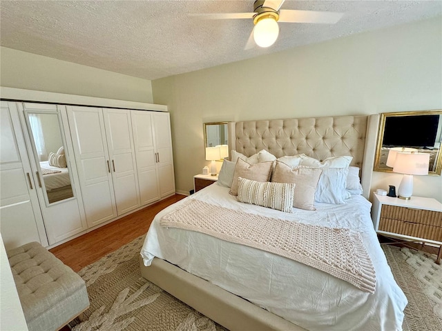 bedroom featuring ceiling fan, light hardwood / wood-style floors, a textured ceiling, and a closet