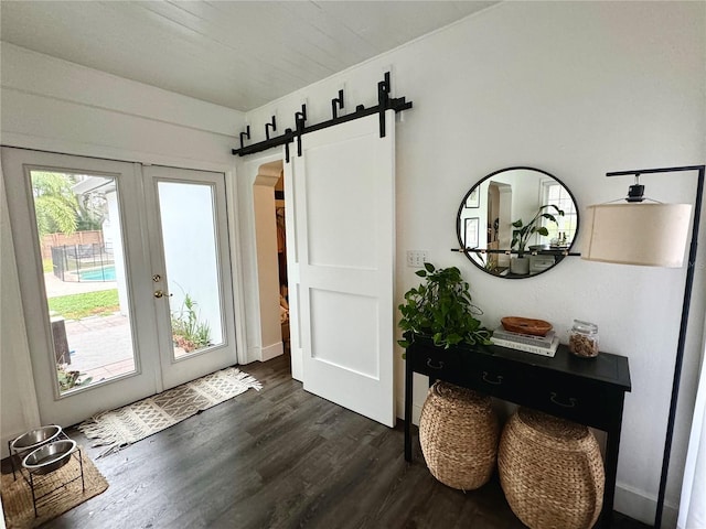 entryway featuring a barn door, french doors, and dark wood-type flooring