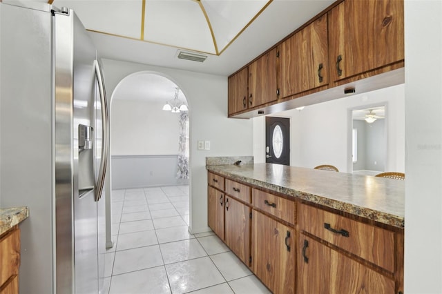 kitchen featuring stainless steel fridge with ice dispenser, ceiling fan with notable chandelier, and light tile patterned floors