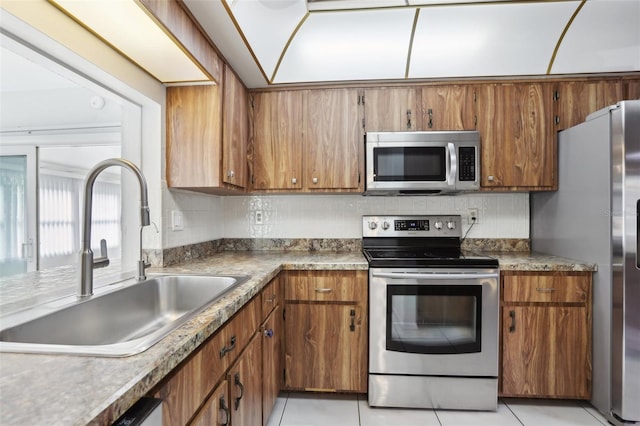 kitchen featuring light tile patterned flooring, stainless steel appliances, tasteful backsplash, and sink