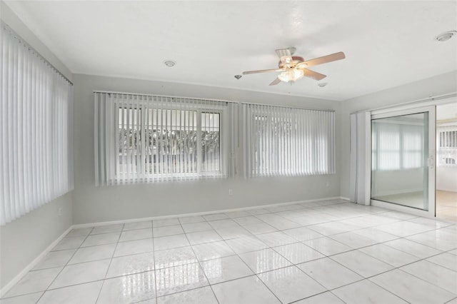 unfurnished room featuring a wealth of natural light, ceiling fan, and light tile patterned flooring