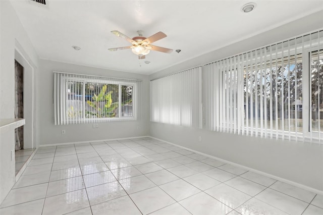 tiled spare room featuring ceiling fan