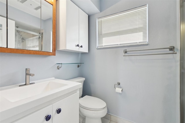 bathroom with tile patterned floors, vanity, toilet, and walk in shower