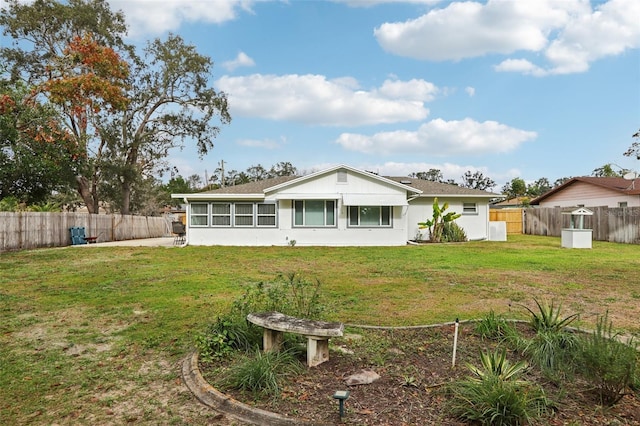 rear view of property featuring a lawn