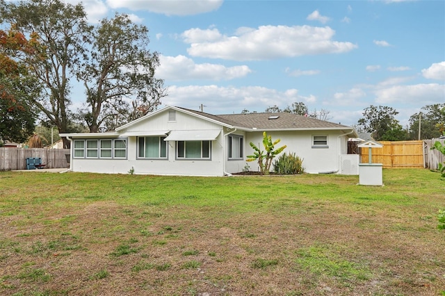 rear view of property featuring a lawn