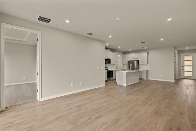 unfurnished living room with sink and light wood-type flooring