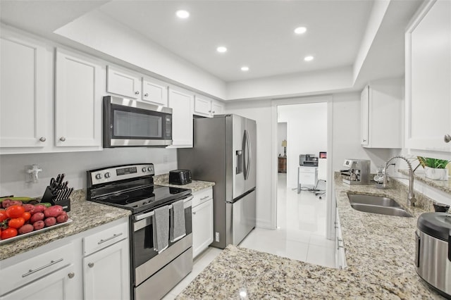 kitchen featuring white cabinetry, sink, stainless steel appliances, and light stone counters