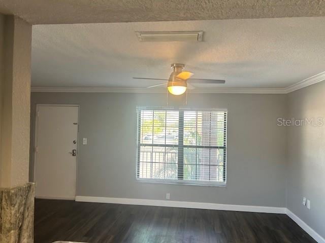 unfurnished room featuring a textured ceiling, ceiling fan, crown molding, and dark wood-type flooring