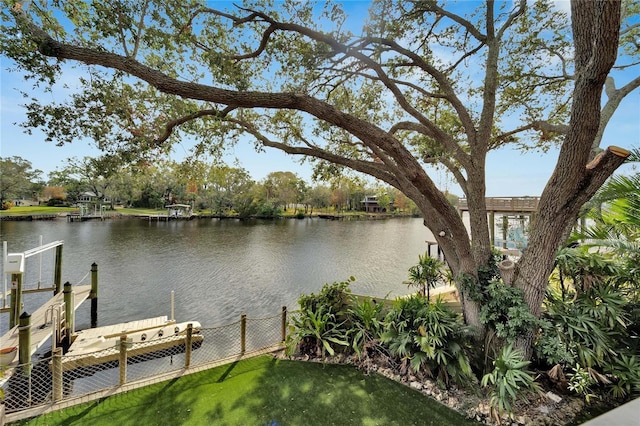 dock area with a lawn and a water view