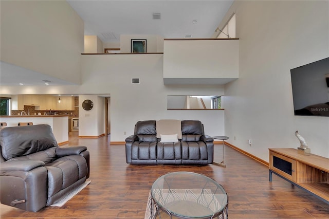 living room featuring hardwood / wood-style flooring and a high ceiling