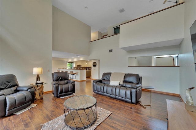 living room featuring hardwood / wood-style floors and a towering ceiling