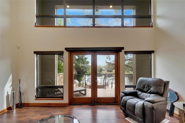 entryway with french doors, dark wood-type flooring, and a high ceiling