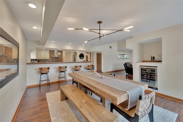 dining area with wine cooler, dark hardwood / wood-style flooring, and a notable chandelier