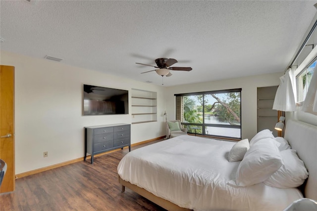 bedroom featuring a textured ceiling, dark hardwood / wood-style floors, and ceiling fan