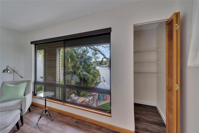 living area with dark hardwood / wood-style flooring and a water view