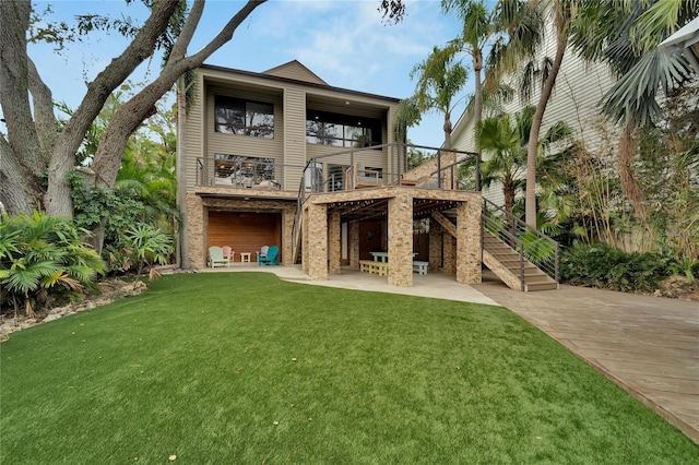 rear view of house with a yard, a balcony, and a patio