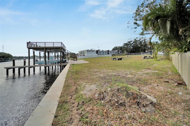 view of dock featuring a yard and a water view