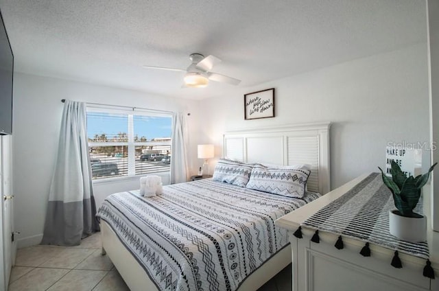 tiled bedroom with a textured ceiling and ceiling fan