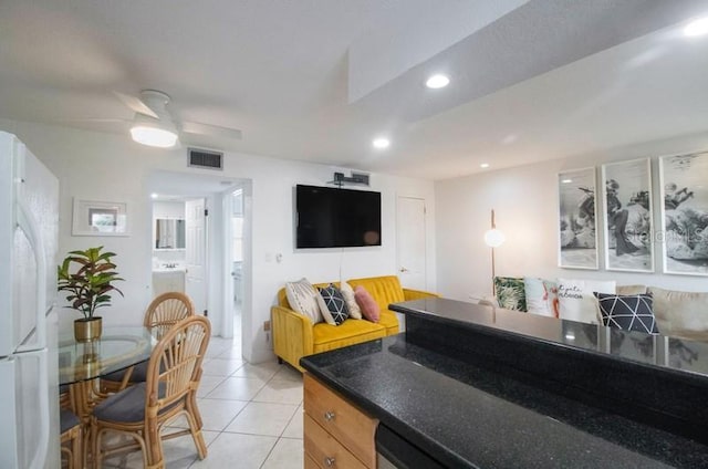 kitchen featuring ceiling fan, white refrigerator, and light tile patterned floors