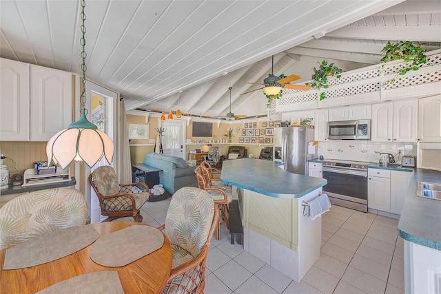 kitchen with vaulted ceiling with beams, ceiling fan, white cabinetry, and appliances with stainless steel finishes