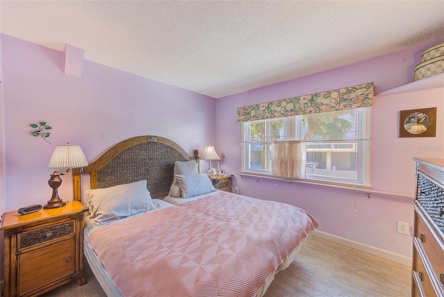 bedroom featuring a textured ceiling and light wood-type flooring